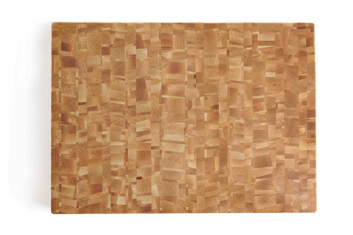 Top-down view of a maple end grain cutting board with a natural checkered wood pattern.