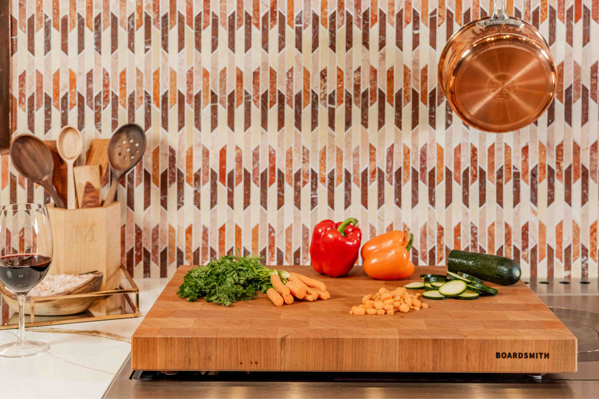 Cherry end grain cutting board by Boardsmith with fresh vegetables in a modern kitchen setting