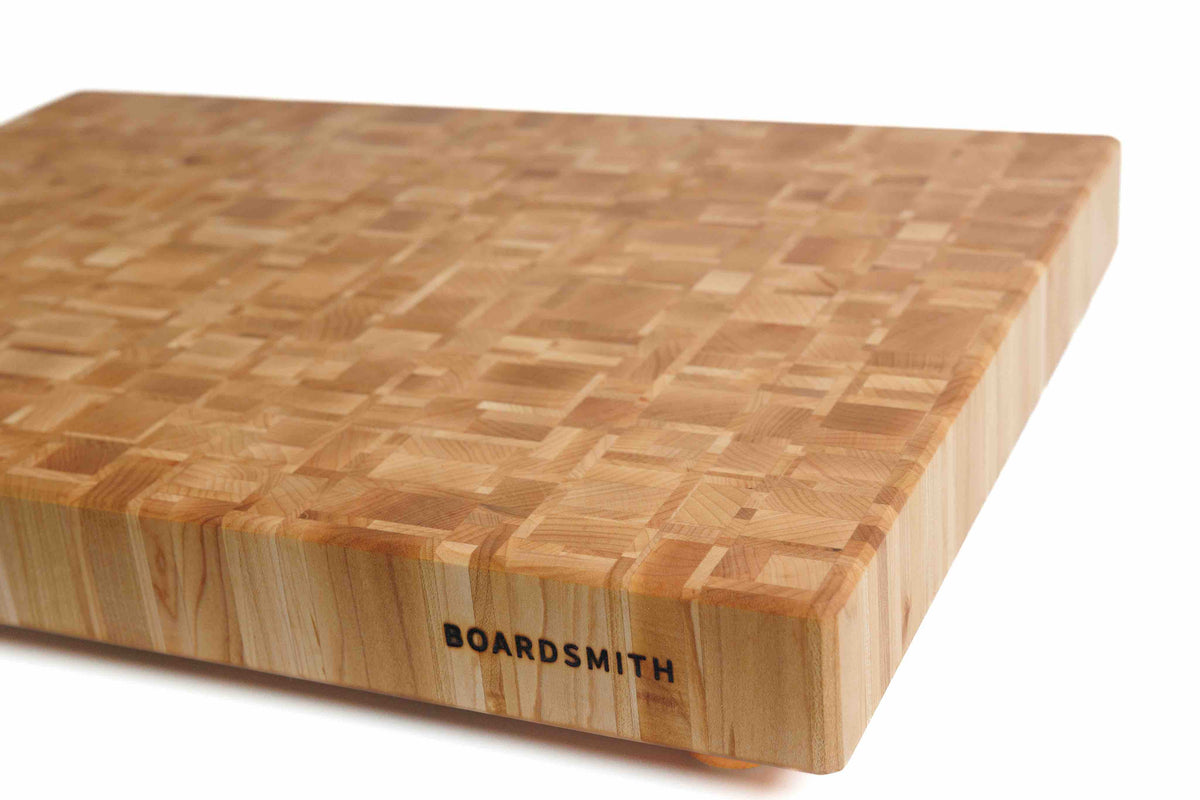 Angled view of a maple end grain cutting board by Boardsmith, showcasing its durable construction and fine wood grain.